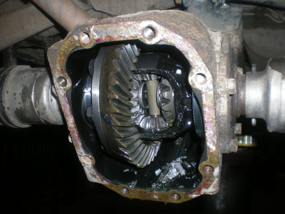 Differential housing with exposed gears, showing wear and damage