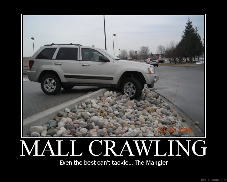 Silver SUV with front wheels on a pile of rocks next to a curb