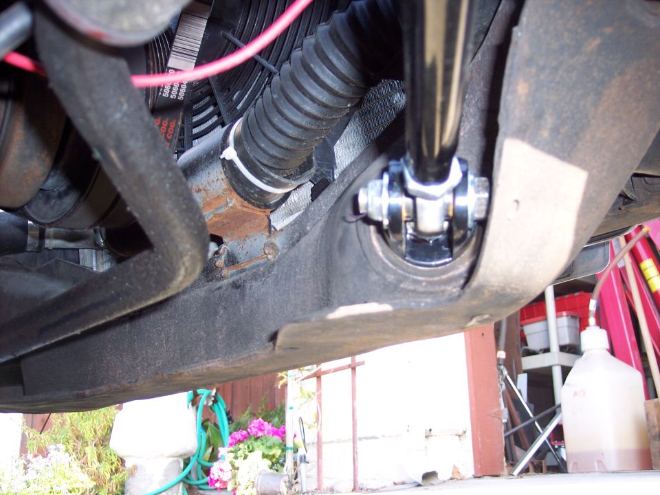 Close-up of a suspension component with a ribbed hose and fan belts