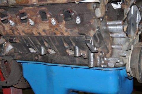 1996 Ford Bronco - Engine block with spark plugs and a blue oil pan, likely undergoing a rebuild.