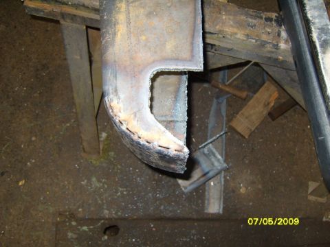 1989 Ford Bronco - A close-up view of a metal part showing recent welds and cut edges, likely a component being repaired or fabricated.