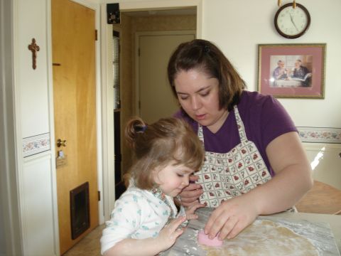 2000 Ford Crown Victoria - A woman and a young child are focused on cutting out cookie shapes from dough on a marble countertop.