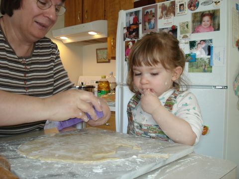 2000 Ford Crown Victoria - A woman and a young child are in a kitchen, working with dough on a marble countertop.