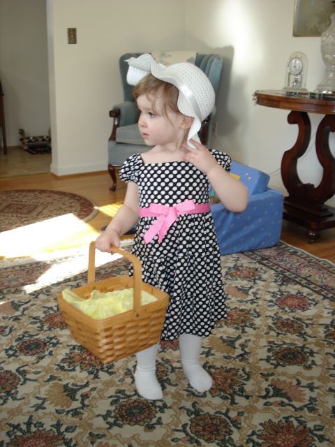 2000 Ford Crown Victoria - A child dressed up for an occasion holds a basket while standing indoors on a patterned rug.