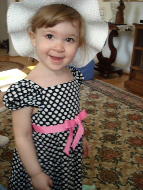 2000 Ford Crown Victoria - A young girl dressed in a polka dot dress and a wide-brimmed hat poses for a photo indoors.