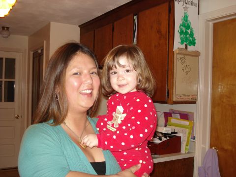 2000 Ford Crown Victoria - A woman holds a young child dressed in red polka dot pajamas in front of kitchen cabinets.