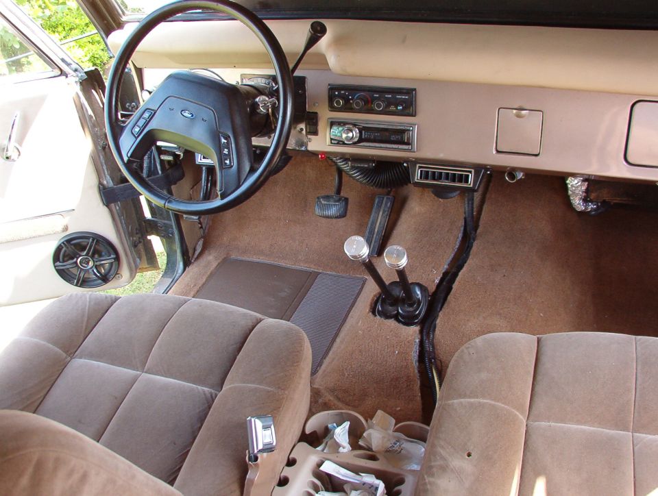 Now that the carpet is in (even with the big gash down the middle), the A/C ducts are now the biggest eyesore.  After this pic, I shot some black paint onto that evaporator insulation below the glove box.

The floorboards under this carpet are now completely covered in DynaMat Xtreme.  The split where the wiring lies will eventually be covered by a custom floor console incorporating an amp & sub, cupholders, switchable lighter sockets, a heated/refrigerated storage bin, defroster & antenna controls, & rear A/C controls.