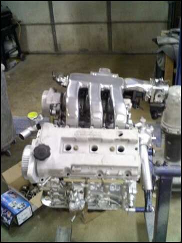 1994 Ford Probe - Engine part shown in a workshop setting, with a website logo at the bottom.