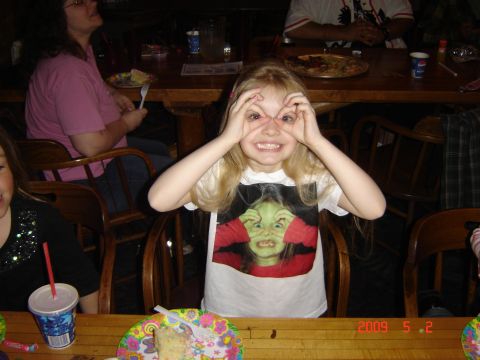 1993 Ford Bronco - A young girl makes a funny face while sitting at a table with cake and drinks.