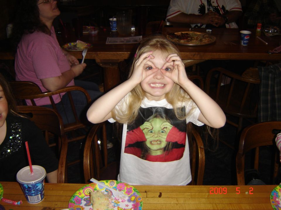 Girl making faces with hands over eyes