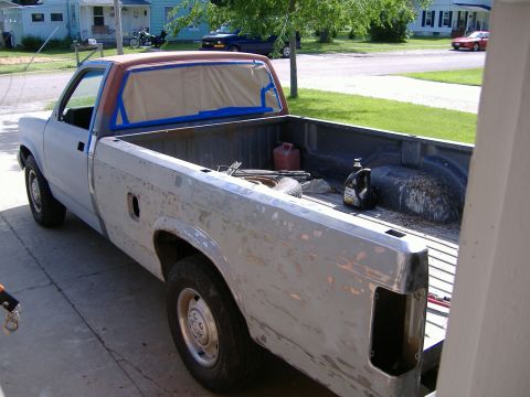 1992 Dodge Dakota - A pickup truck is undergoing bodywork and preparation for a new paint job.