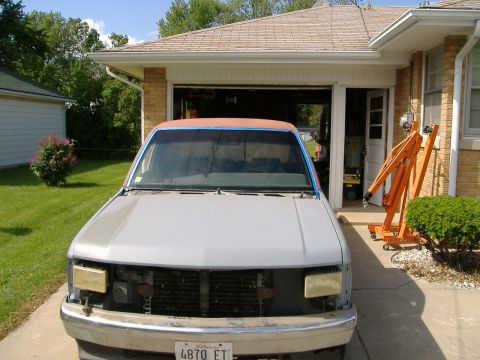 1992 Dodge Dakota - A truck in need of repair sits outside a garage, with an engine hoist nearby.