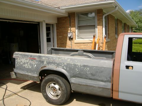 1992 Dodge Dakota - This truck bed is undergoing preparation for a new paint job, showing areas of rust and old paint removal.