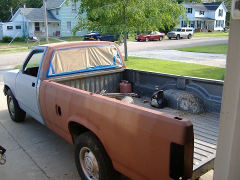 1992 Dodge Dakota - Truck bed contents and background vehicles. The truck itself is partially prepped for paint.