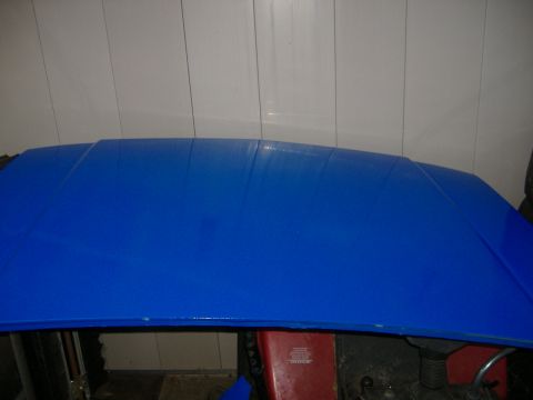 1992 Dodge Dakota - The hood of a car is painted bright blue, showing some imperfections in the paintwork.