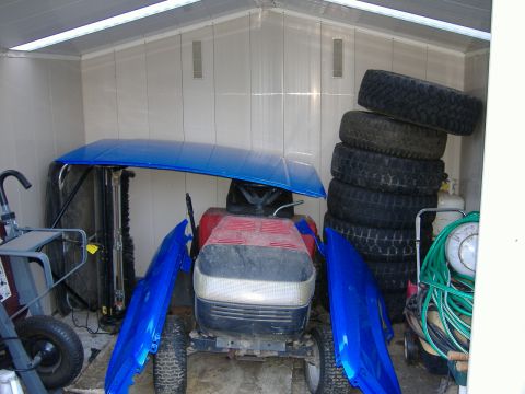 1992 Dodge Dakota - A red and black lawn mower is partially disassembled, with blue fenders and hood components placed around it.