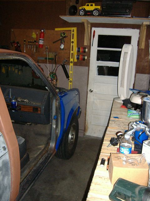 1992 Dodge Dakota - The interior of a blue pickup truck is visible, with the doors removed and tools hanging on the wall behind it.