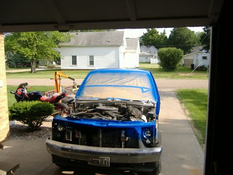 1992 Dodge Dakota - Pickup truck undergoing repairs or repainting, with engine compartment visible and front end protected by plastic sheeting.