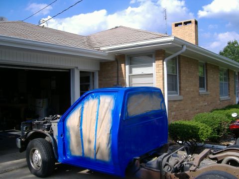 1992 Dodge Dakota - A pickup truck cab is being prepped for painting, with masking tape covering the windows and door panels.