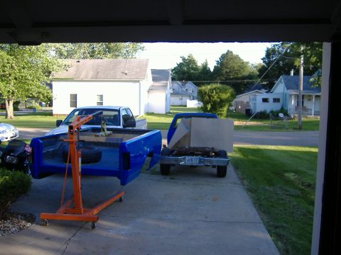 1992 Dodge Dakota - A blue pickup truck bed is being worked on with an engine hoist, while the truck's chassis sits nearby.