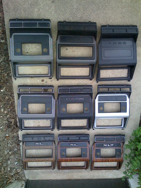 1984 Ford F-250 - Various dashboard trim pieces for Ford trucks are laid out on a concrete surface.