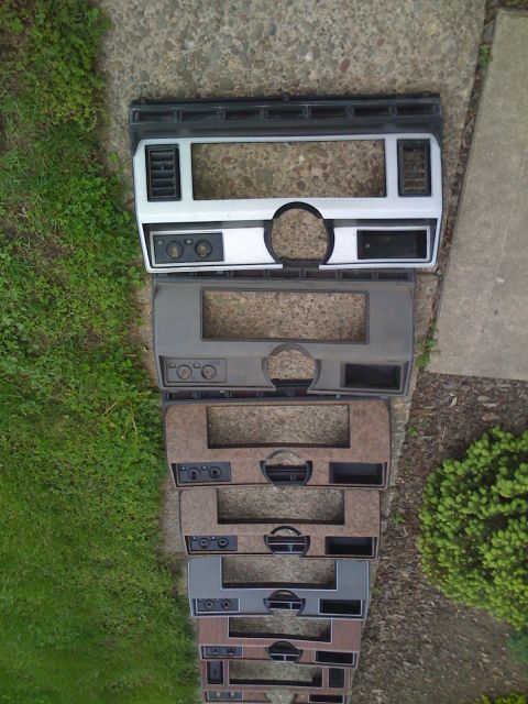 1984 Ford F-250 - Several dashboard trim pieces are laid out, showing different colors and woodgrain patterns.