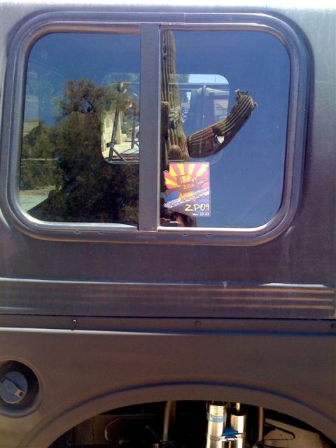 1987 Suzuki Samurai - A sticker is visible on the window of a Suzuki Samurai, reflecting a saguaro cactus and desert landscape.