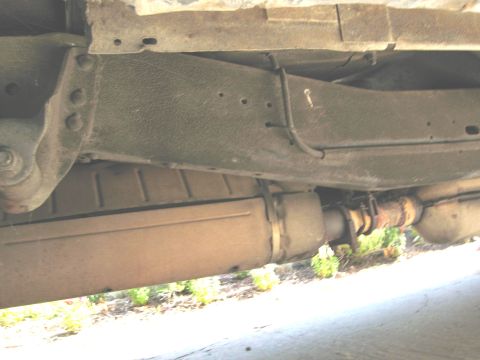 1986 Ford Bronco - Underside view of a vehicle's frame and exhaust system, with visible rust and wear.