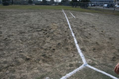 1990 Chevrolet Suburban - A view of a softball field, showing the base lines and home plate area marked with white paint.
