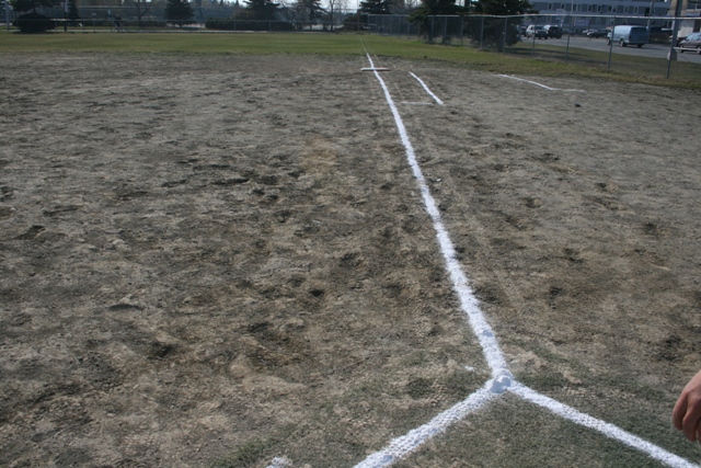 Softball field with white base lines and home plate markings