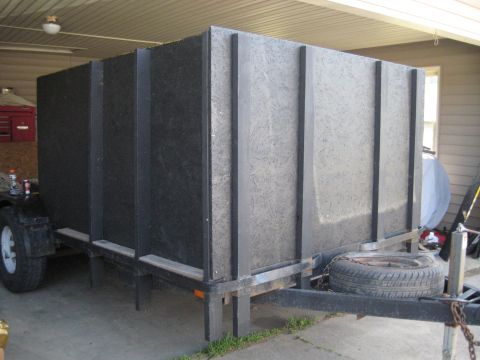 1900 Ford C-350 (Centurion Conversions) - A utility trailer carries a large, dark, enclosed cargo box, possibly for moving goods.