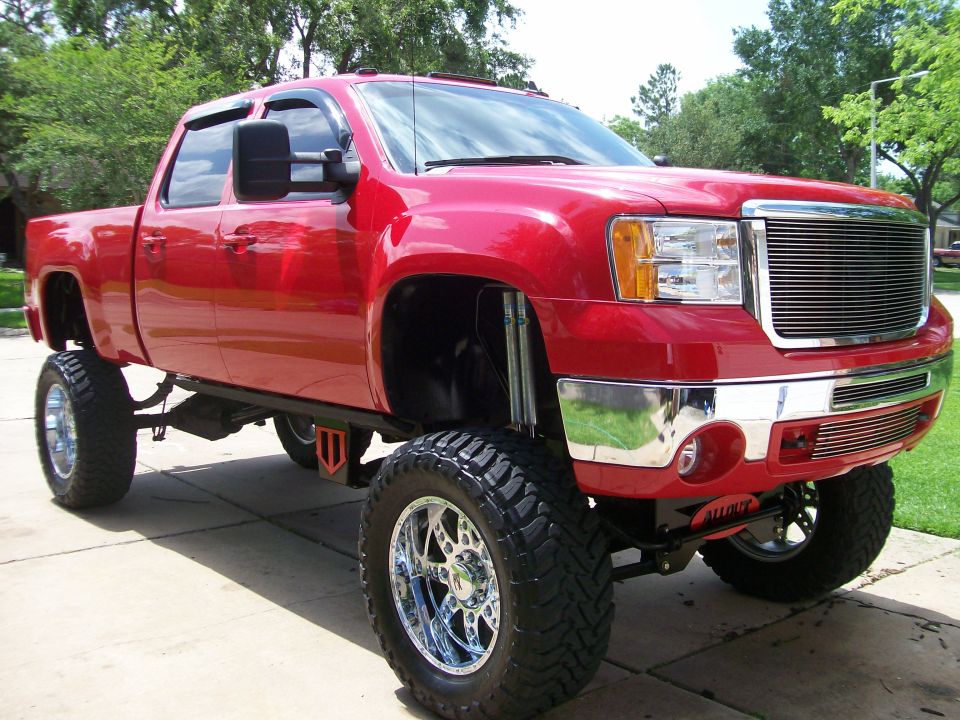 Red pickup truck with lifted suspension and chrome wheels