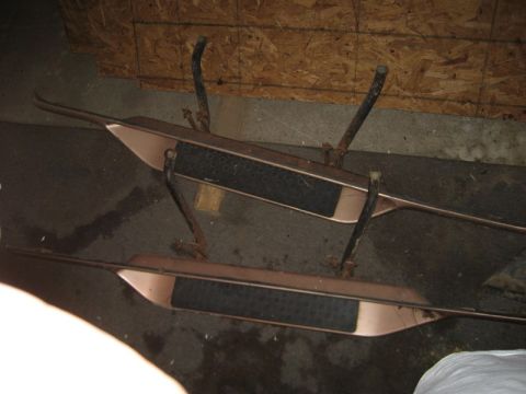 1995 Ford Bronco - Two vehicle running boards are shown indoors, resting on a concrete floor.