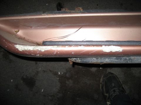 1995 Ford Bronco - Close-up of a damaged vehicle body panel showing wear and tear.