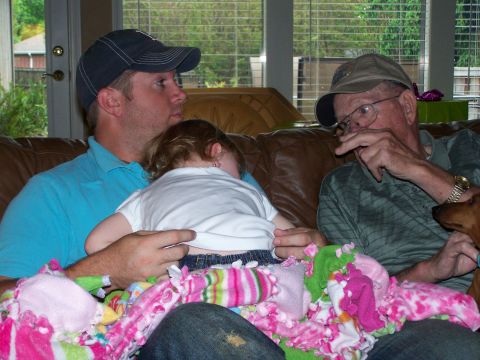 1978 Ford Bronco - Three people and a dog relax on a couch, with a child asleep on one man's lap.