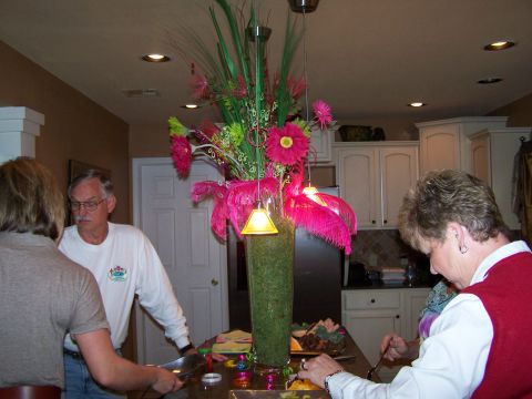 1978 Ford Bronco - A group of people are socializing in a kitchen, with a large floral centerpiece on the counter.