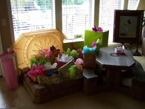1978 Ford Bronco - A collection of presents and gift bags are arranged around a toy picnic table indoors.