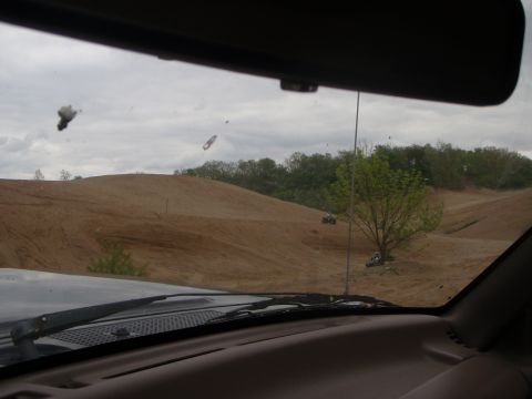1996 Ford Bronco - ATVs navigate sandy trails in an off-road park, viewed from inside another vehicle.