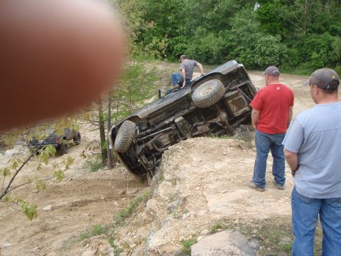 1996 Ford Bronco - An off-road vehicle has overturned on a steep, rocky slope while another vehicle watches.