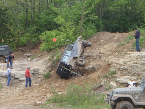 1996 Ford Bronco - An off-road vehicle has tipped onto its side while navigating a steep, rocky incline.