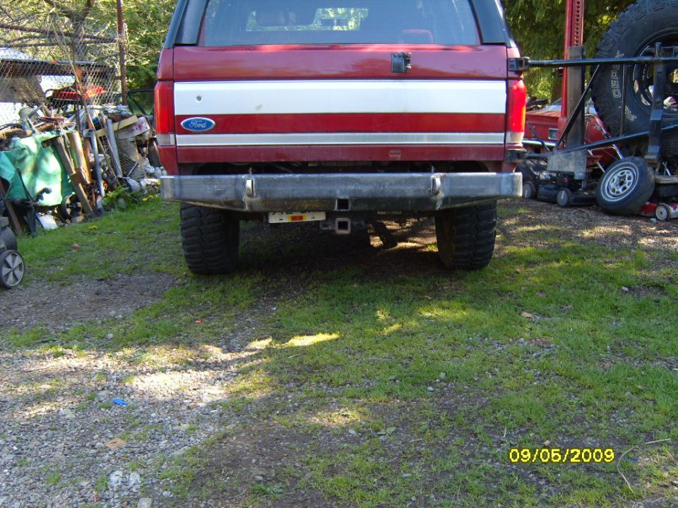 Red 1989 Ford Bronco rear with chrome stripe and aftermarket bumper