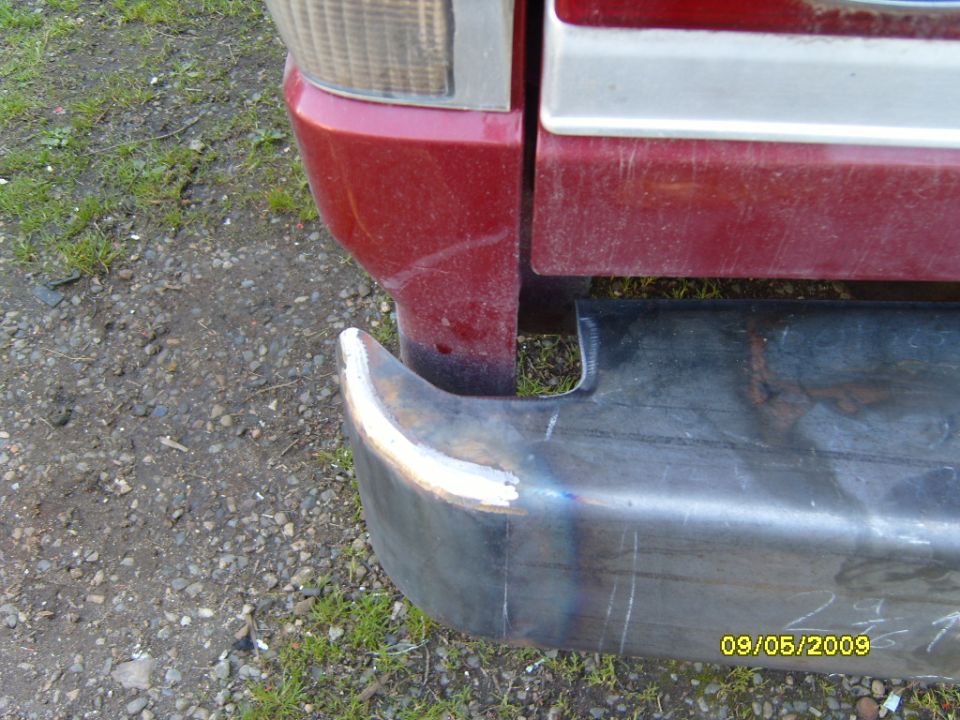 Rear bumper corner and part of red body panel with taillight assembly