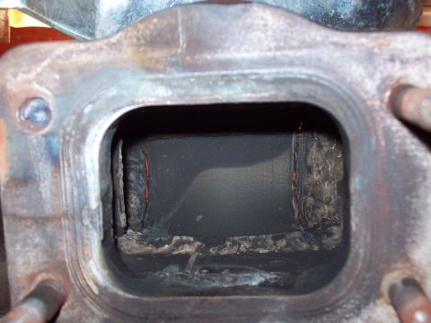 1986 Toyota Hilux - Close-up view of the inside of an exhaust manifold, showing significant carbon deposits and wear.