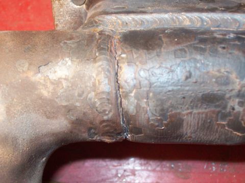 1986 Toyota Hilux - This is a close-up view of a welded metal pipe, likely part of an exhaust system, showing signs of wear and repair.
