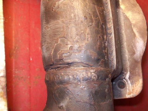 1986 Toyota Hilux - Close-up of a heavily corroded exhaust manifold with visible weld marks and peeling paint.