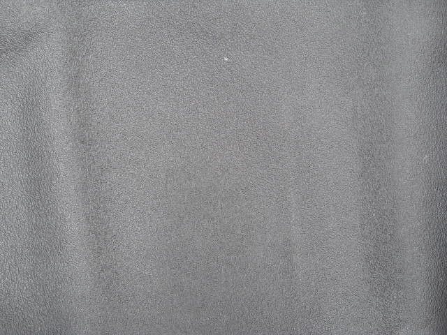 Gray textured surface with a small white speck and a Supermotors logo in the lower right corner