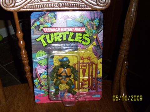 1991 Ford Bronco - A packaged Leonardo action figure from Teenage Mutant Ninja Turtles is displayed on a wooden surface.