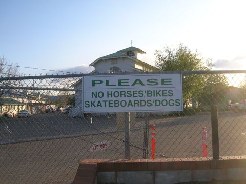 1996 Ford Bronco - A sign restricts activities in an area, with a building and trees in the background.