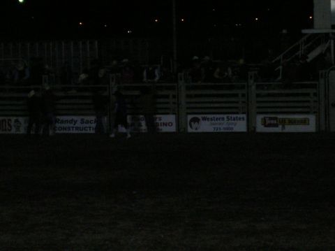 1996 Ford Bronco - A nighttime view of a rodeo arena, showing the stands and various sponsor advertisements along the barriers.