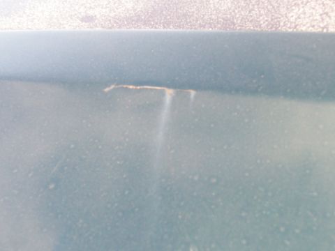 1995 Ford C-350 (Centurion Conversions) - A crack in the paint on a vehicle's body shows underlying rust and discoloration.